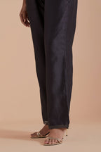 Dark grey silk chanderi straight pants detailed with scalloped organza edging at the hem, delicately highlighted with gold zari quilting.