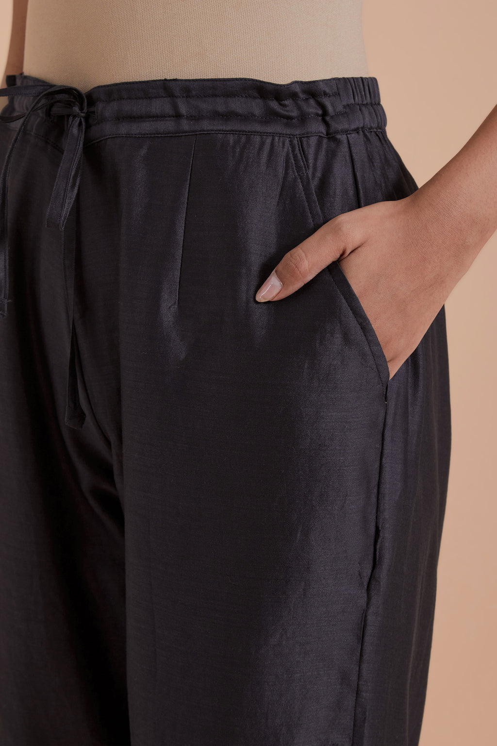 Dark grey silk chanderi straight pants detailed with scalloped organza edging at the hem, delicately highlighted with gold zari quilting.