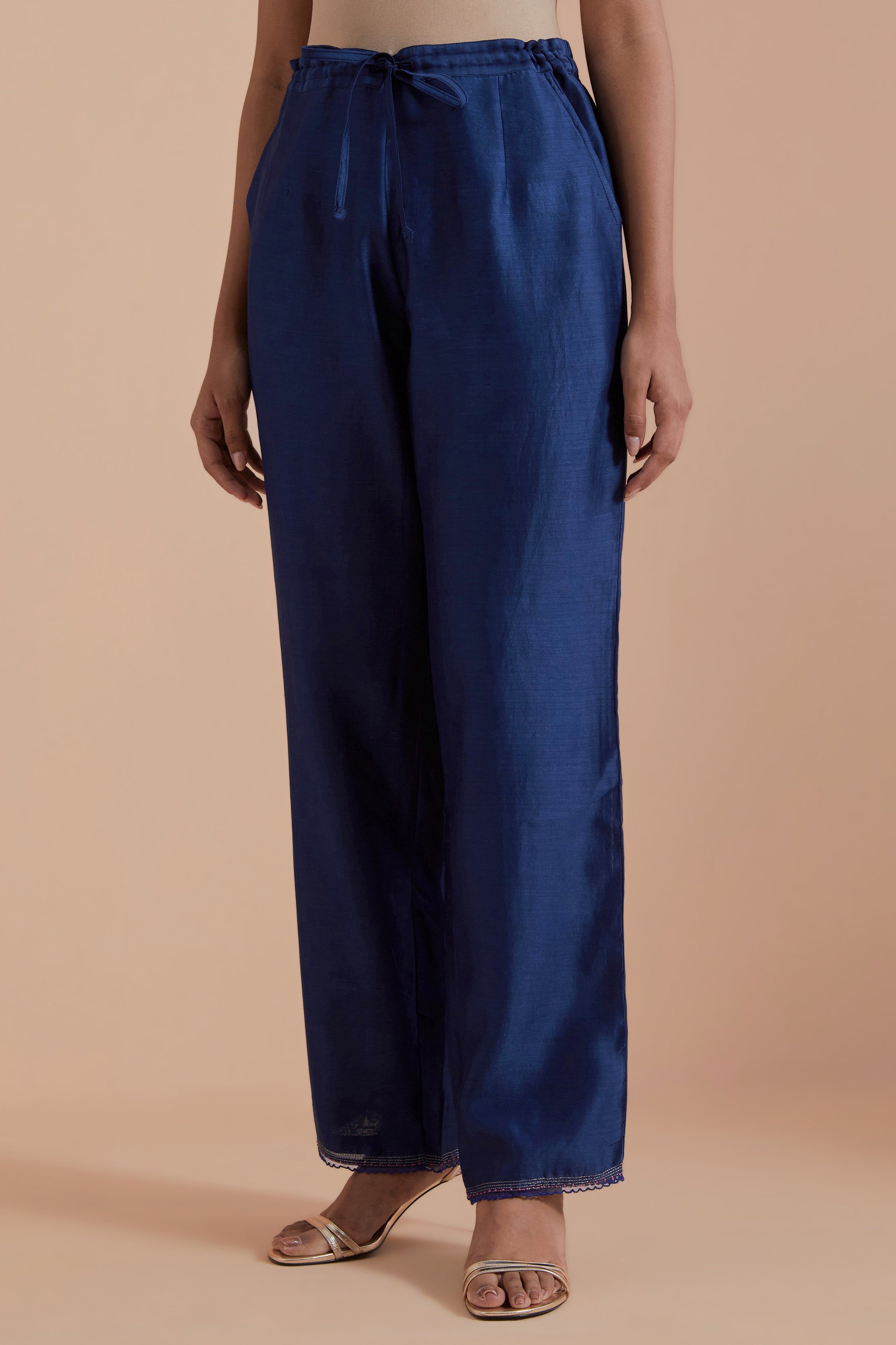 Blue silk chanderi straight pants detailed with scalloped organza edging at the hem, delicately highlighted with gold zari quilting.