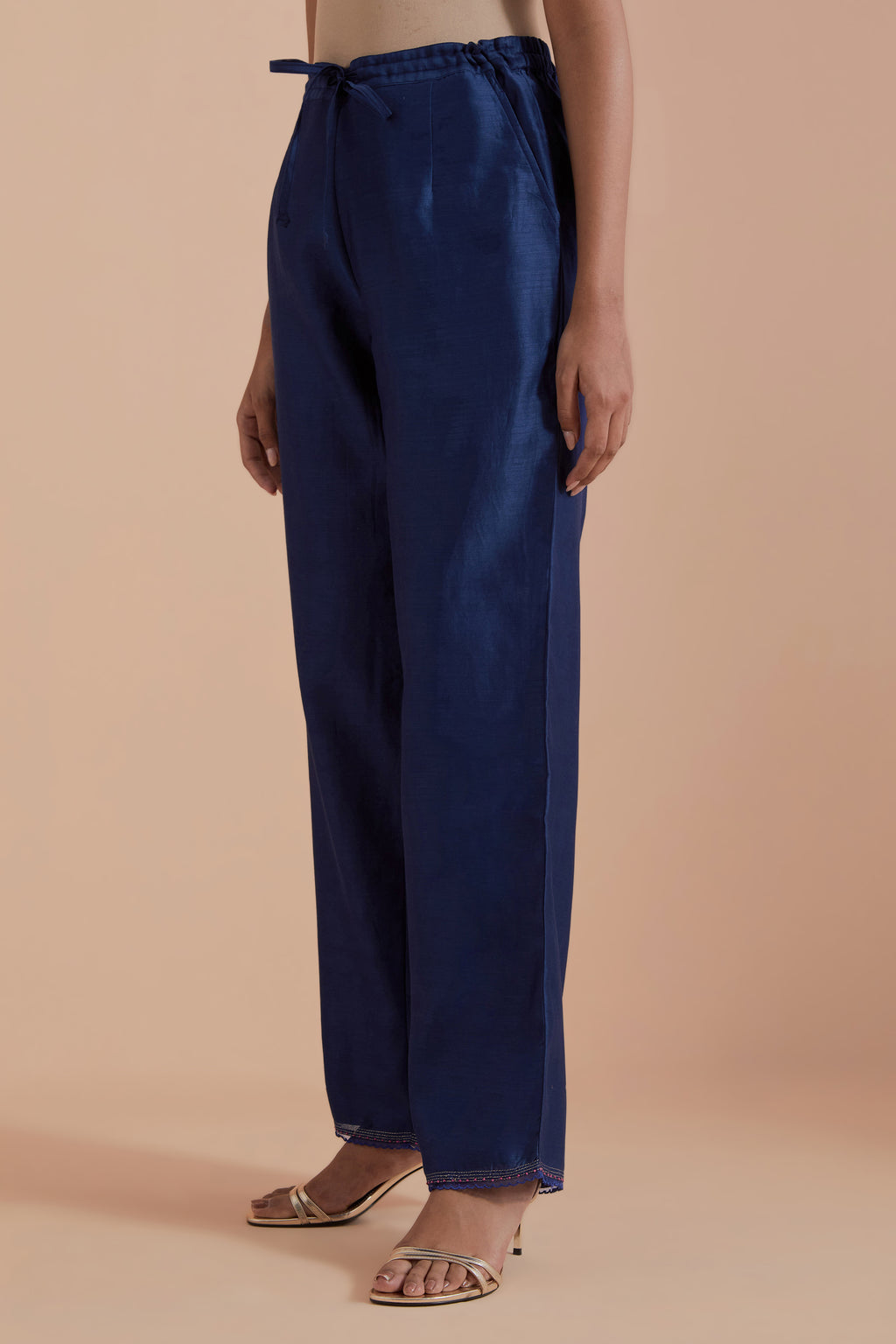 Blue silk chanderi straight pants detailed with scalloped organza edging at the hem, delicately highlighted with gold zari quilting.