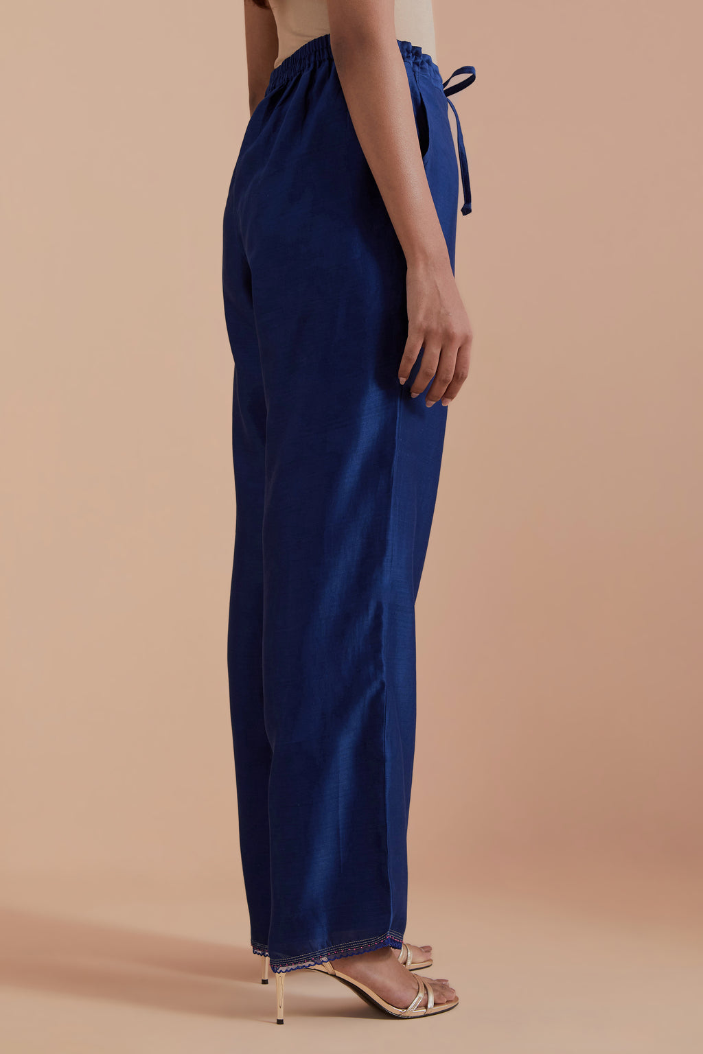 Blue silk chanderi straight pants detailed with scalloped organza edging at the hem, delicately highlighted with gold zari quilting.