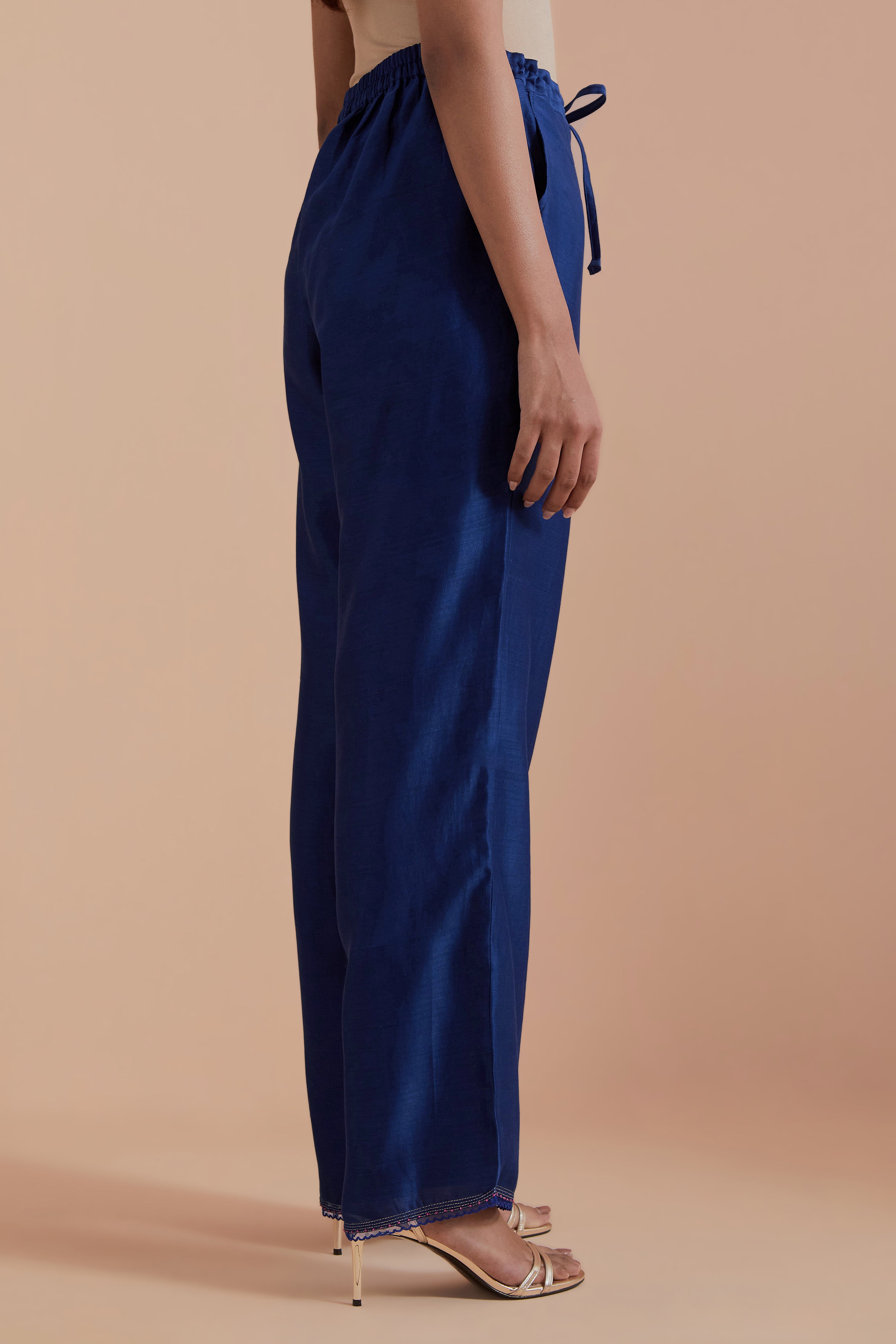 Blue silk chanderi straight pants detailed with scalloped organza edging at the hem, delicately highlighted with gold zari quilting.