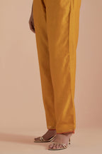 Mustard silk chanderi straight pants detailed with scalloped organza edging at the hem, delicately highlighted with gold zari quilting.