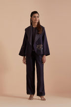 A Dark grey silk Chanderi jacket layered with quilted Silk Organza and delicate Silk Brocade floral appliquéd bootas. Paired with Dark grey silk chanderi straight pants.