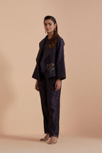 A Dark grey silk Chanderi jacket layered with quilted Silk Organza and delicate Silk Brocade floral appliquéd bootas. Paired with Dark grey silk chanderi straight pants.