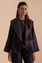 A Dark grey silk Chanderi jacket layered with quilted Silk Organza and delicate Silk Brocade floral appliquéd bootas. Paired with Dark grey silk chanderi straight pants.