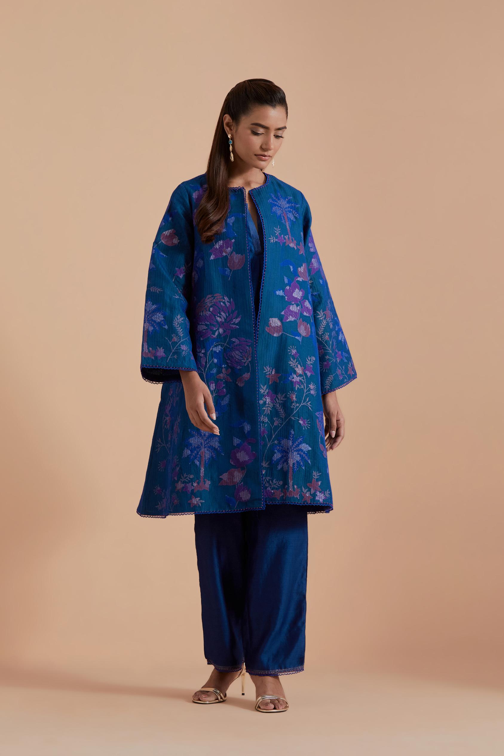 Blue short front open A-line jacket set layered with quilted Silk Organza and delicate Silk Brocade floral appliquéd bootas. Paired with Blue silk chanderi straight pants