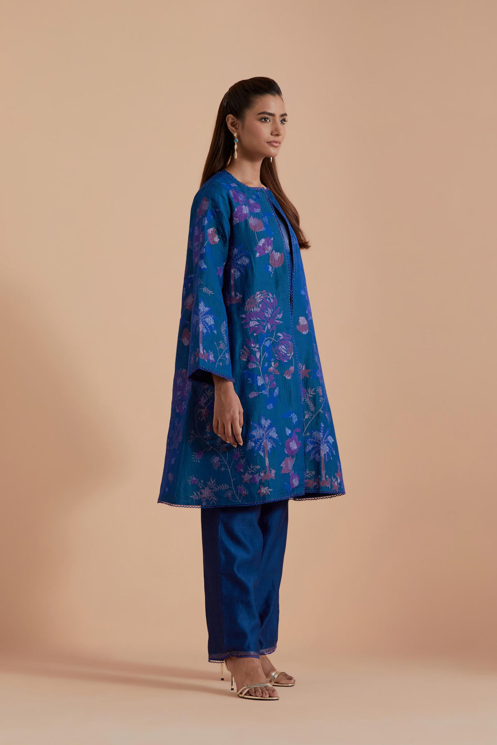 Blue short front open A-line jacket set layered with quilted Silk Organza and delicate Silk Brocade floral appliquéd bootas. Paired with Blue silk chanderi straight pants