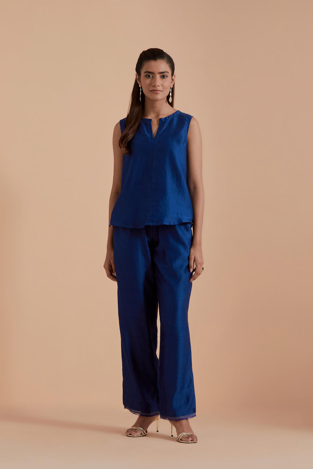 A Blue silk Chanderi jacket layered with quilted Silk Organza and delicate Silk Brocade floral appliquéd bootas. Paired with Blue silk chanderi straight pants.