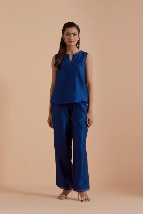 A Blue silk Chanderi jacket layered with quilted Silk Organza and delicate Silk Brocade floral appliquéd bootas. Paired with Blue silk chanderi straight pants.