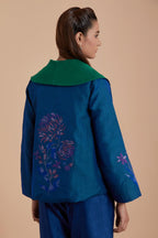 A Blue silk Chanderi jacket layered with quilted Silk Organza and delicate Silk Brocade floral appliquéd bootas. Paired with Blue silk chanderi straight pants.