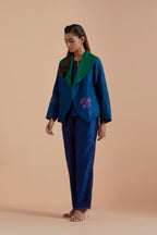 A Blue silk Chanderi jacket layered with quilted Silk Organza and delicate Silk Brocade floral appliquéd bootas. Paired with Blue silk chanderi straight pants.