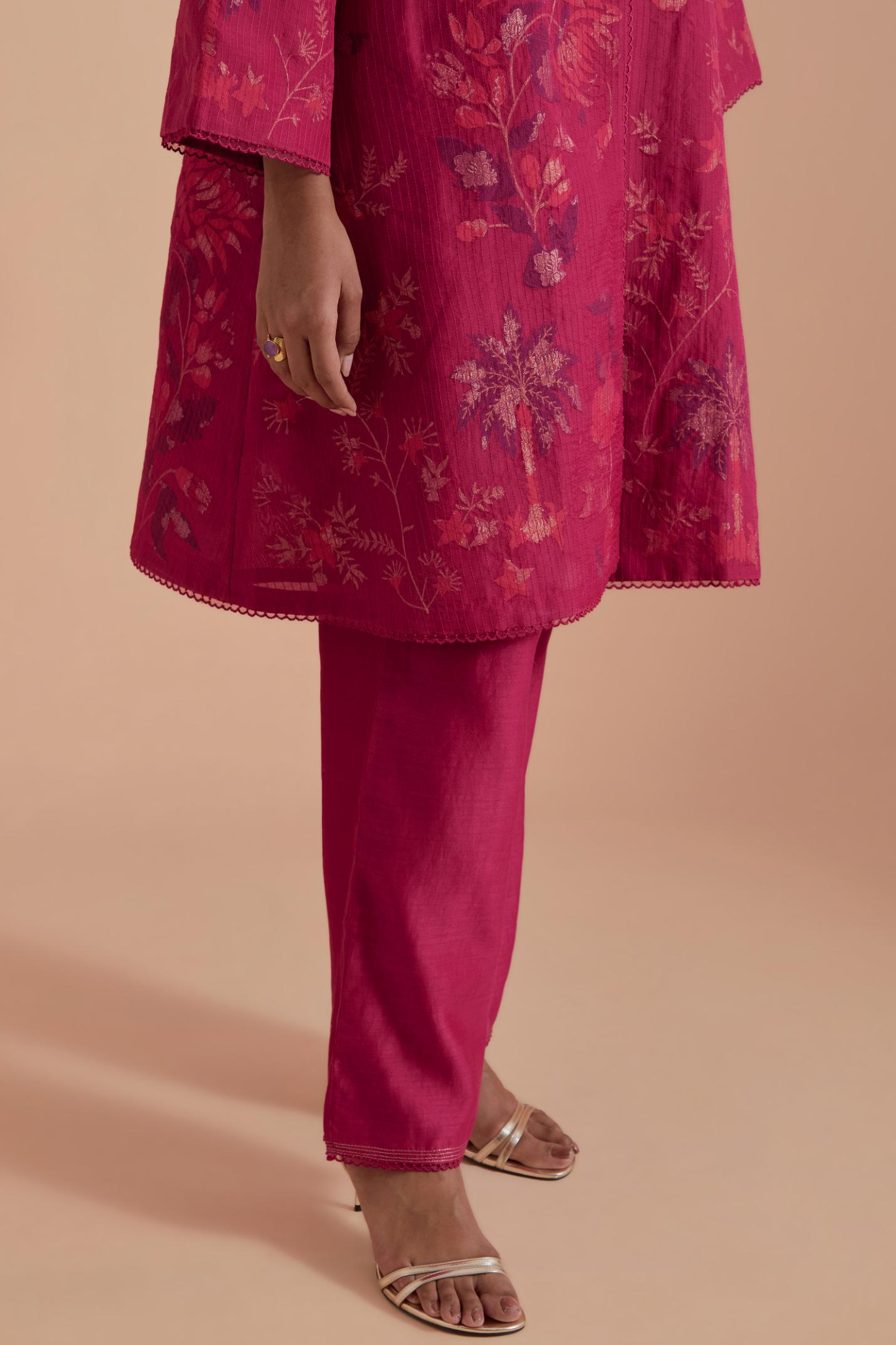Fuchsia short front open A-line jacket set layered with quilted Silk Organza and delicate Silk Brocade floral appliquéd bootas. Paired with fuchsia silk chanderi straight pants.