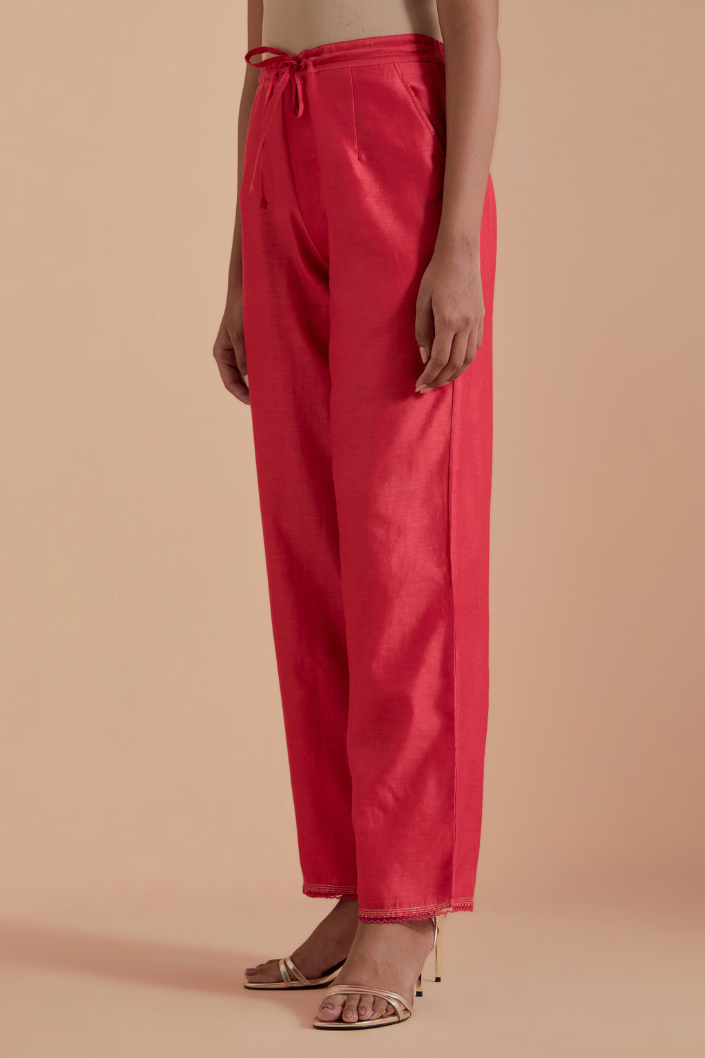 Orange silk chanderi straight pants detailed with scalloped organza edging at the hem, delicately highlighted with gold zari quilting.