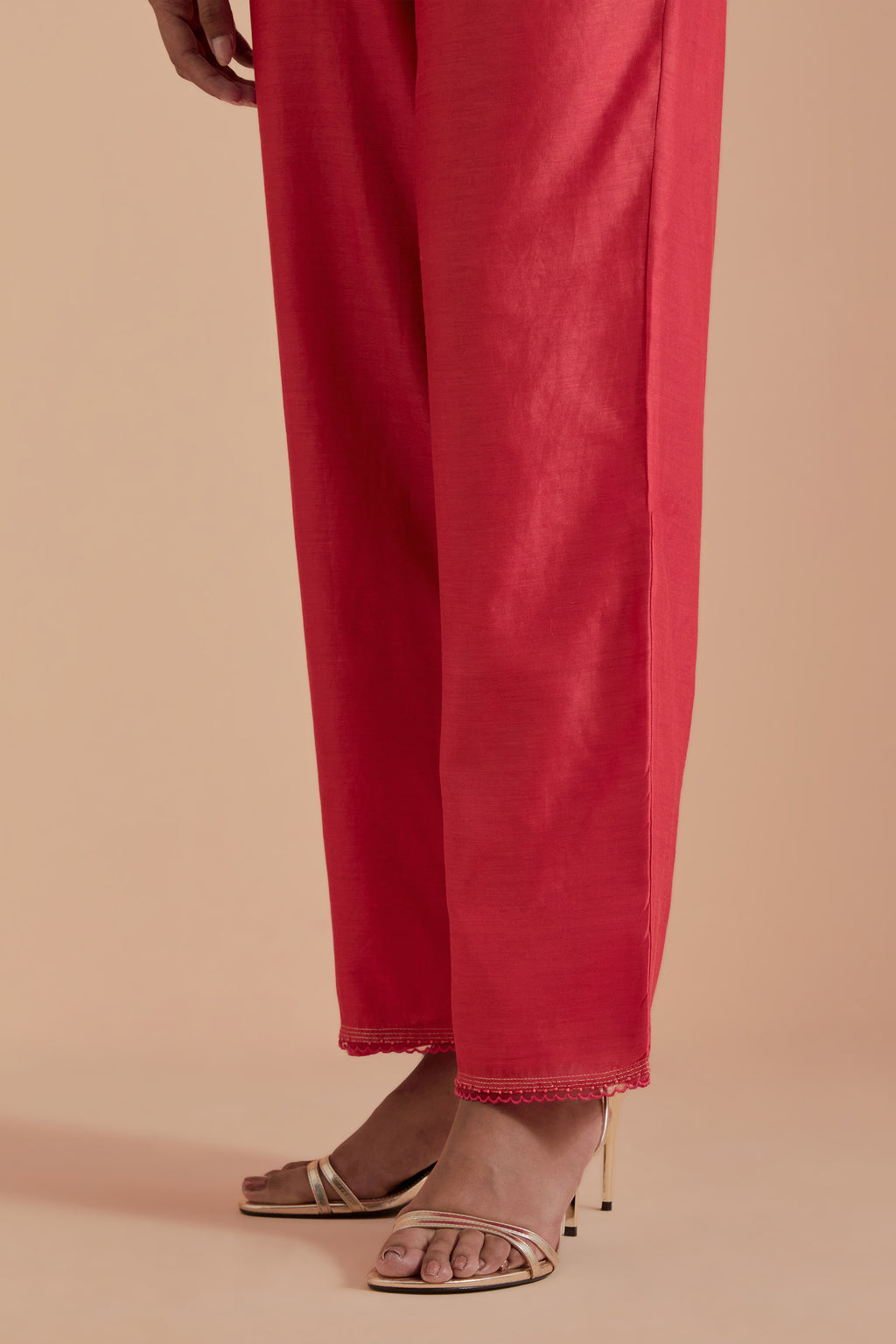 Orange silk chanderi straight pants detailed with scalloped organza edging at the hem, delicately highlighted with gold zari quilting.