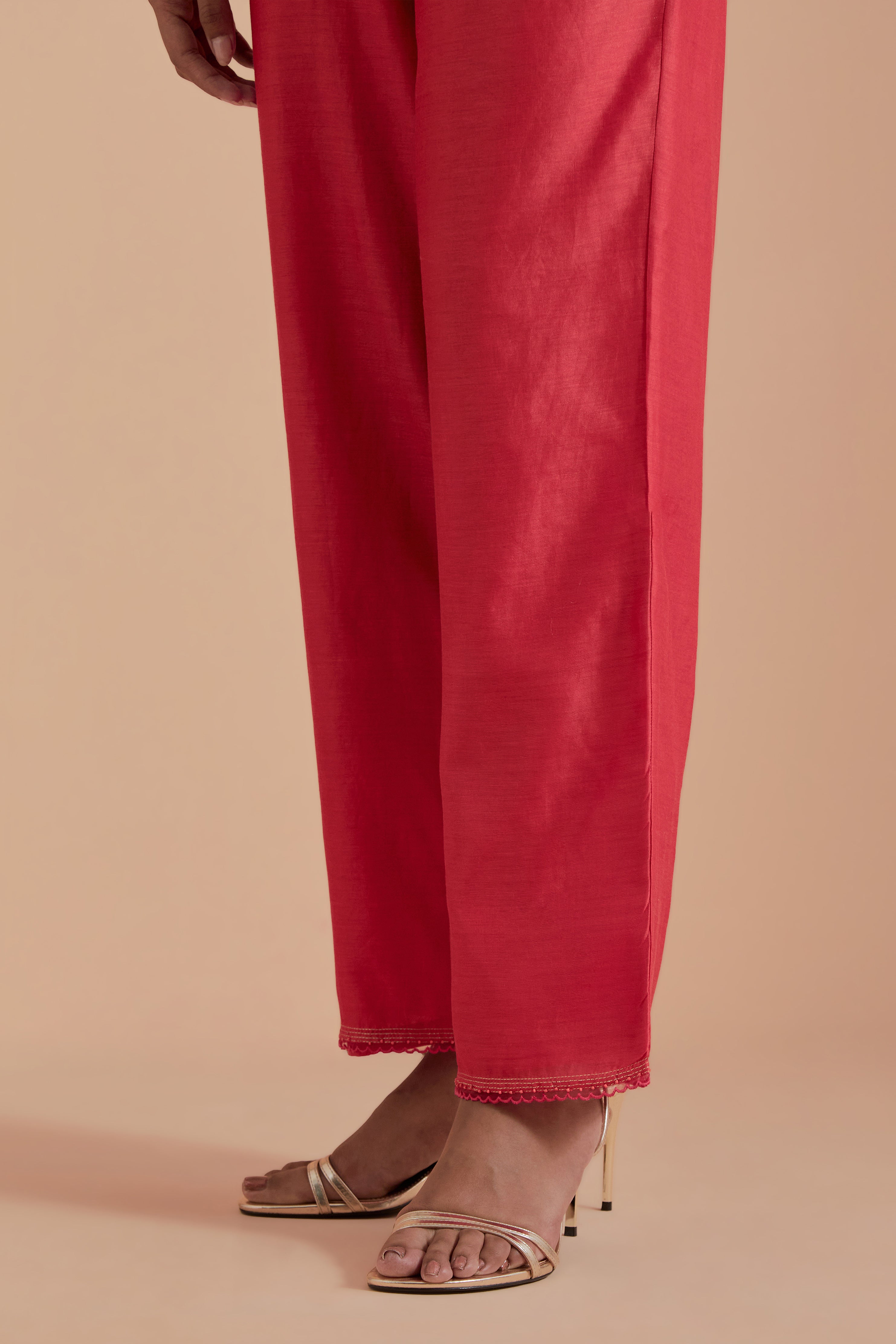 Orange silk chanderi straight pants detailed with scalloped organza edging at the hem, delicately highlighted with gold zari quilting.