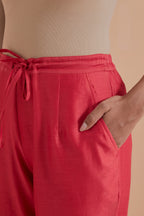 Orange silk chanderi straight pants detailed with scalloped organza edging at the hem, delicately highlighted with gold zari quilting.