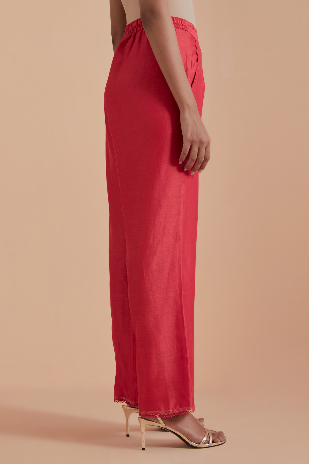 Orange silk chanderi straight pants detailed with scalloped organza edging at the hem, delicately highlighted with gold zari quilting.