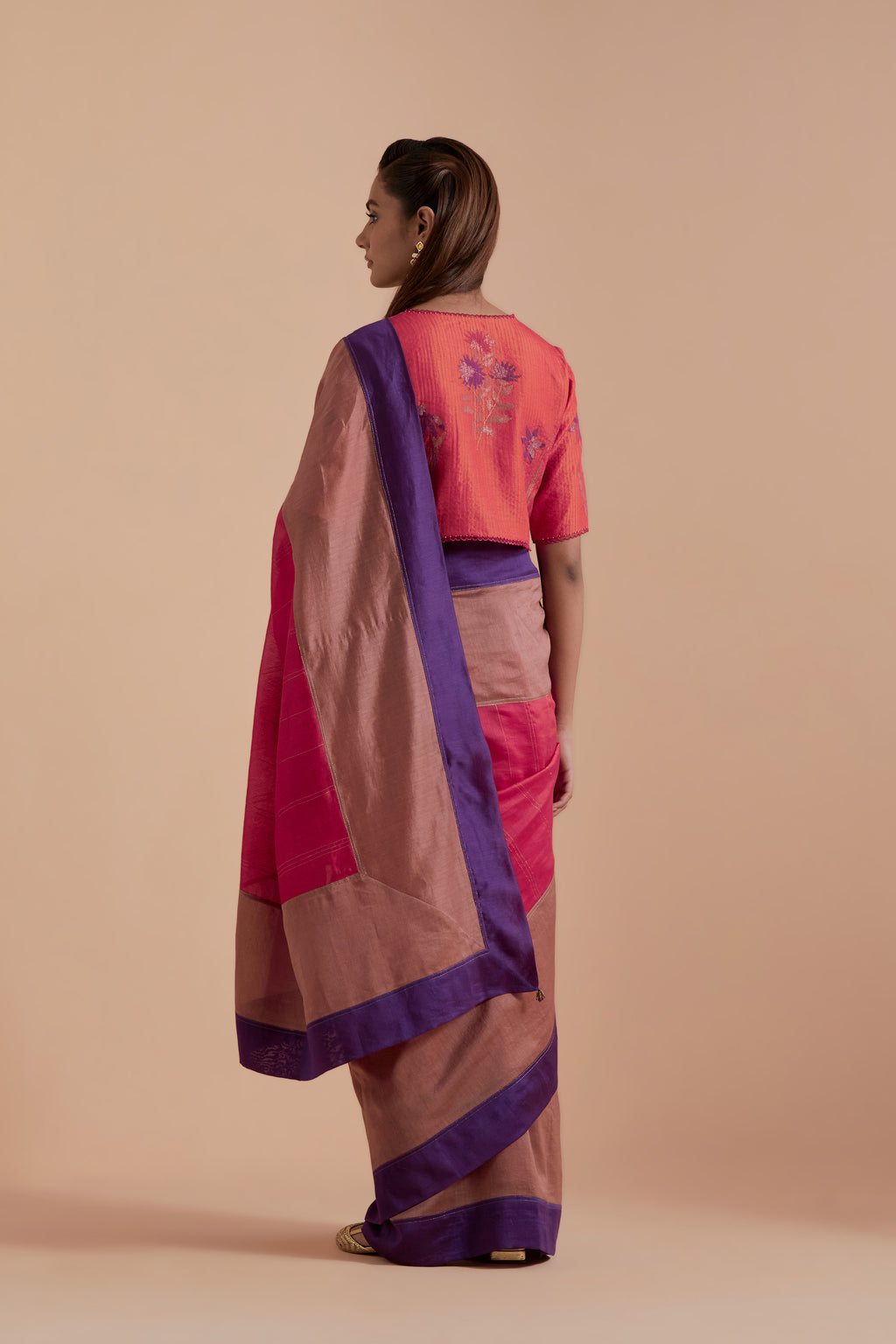 A silk Chanderi three-tone Carrot pink saree in a beautiful gradient effect featuring delicate golden zari quilting all over. Paired with Carrot pink silk Chanderi Quilted Organza & Brocade Floral Appliqué blouse.