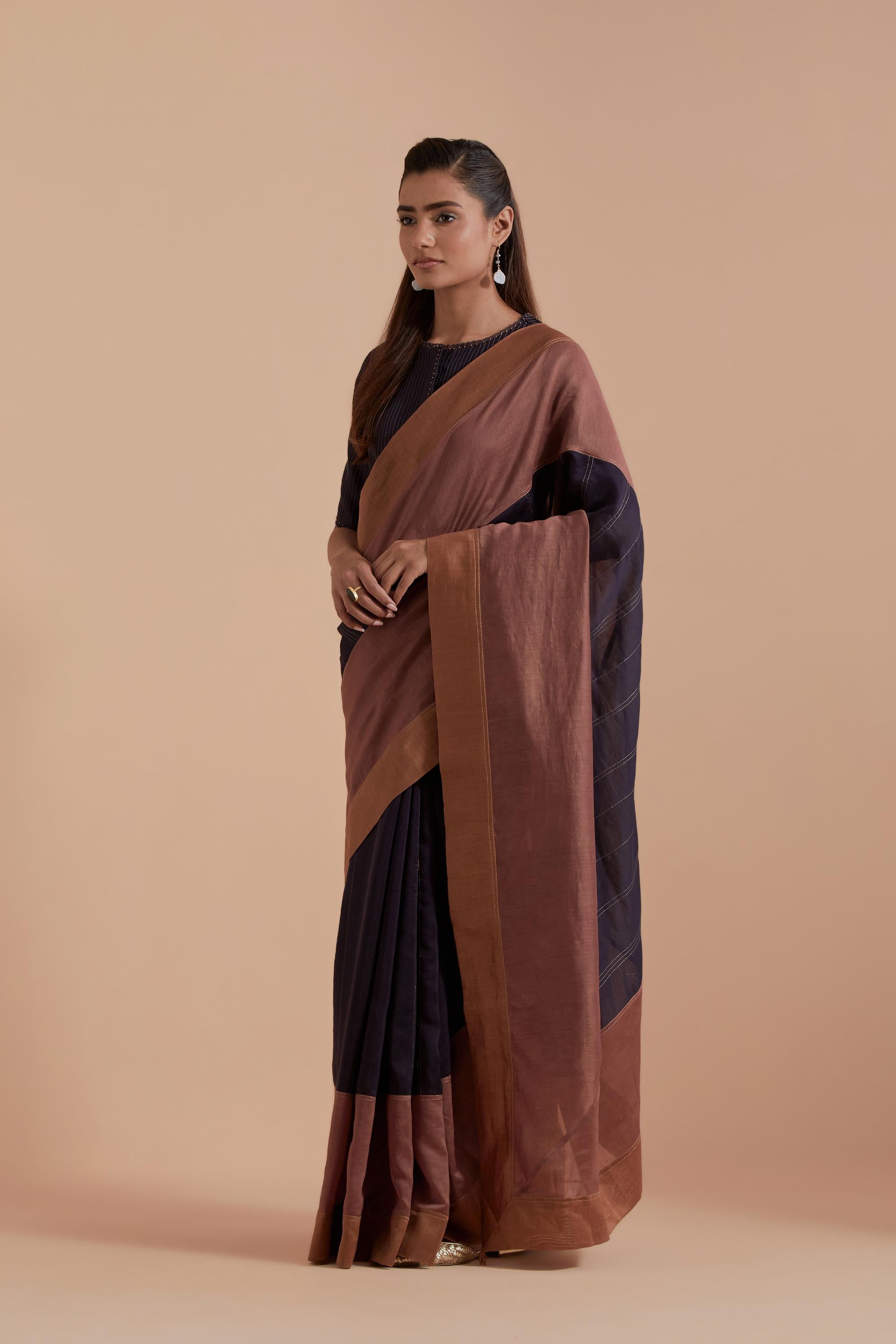 A silk Chanderi three-tone Dark Grey saree in a beautiful gradient effect featuring delicate golden zari quilting all over. Paired with Dark Grey silk Chanderi Quilted Organza & Brocade Floral Appliqué blouse.