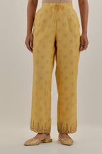 Yellow tissue chanderi straight pants with light gold dori embroidery at hem.