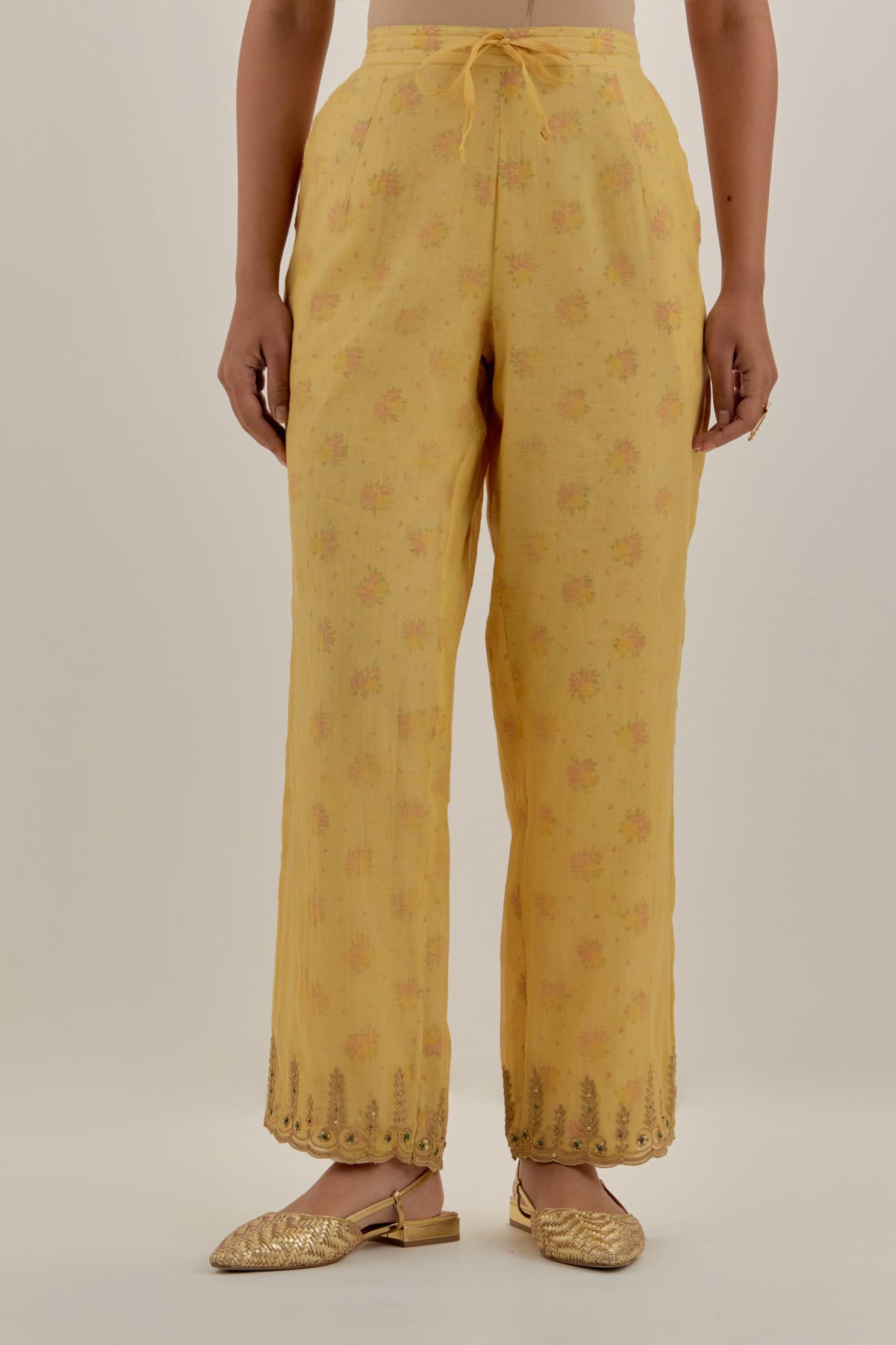 Yellow tissue chanderi straight pants with light gold dori embroidery at hem.