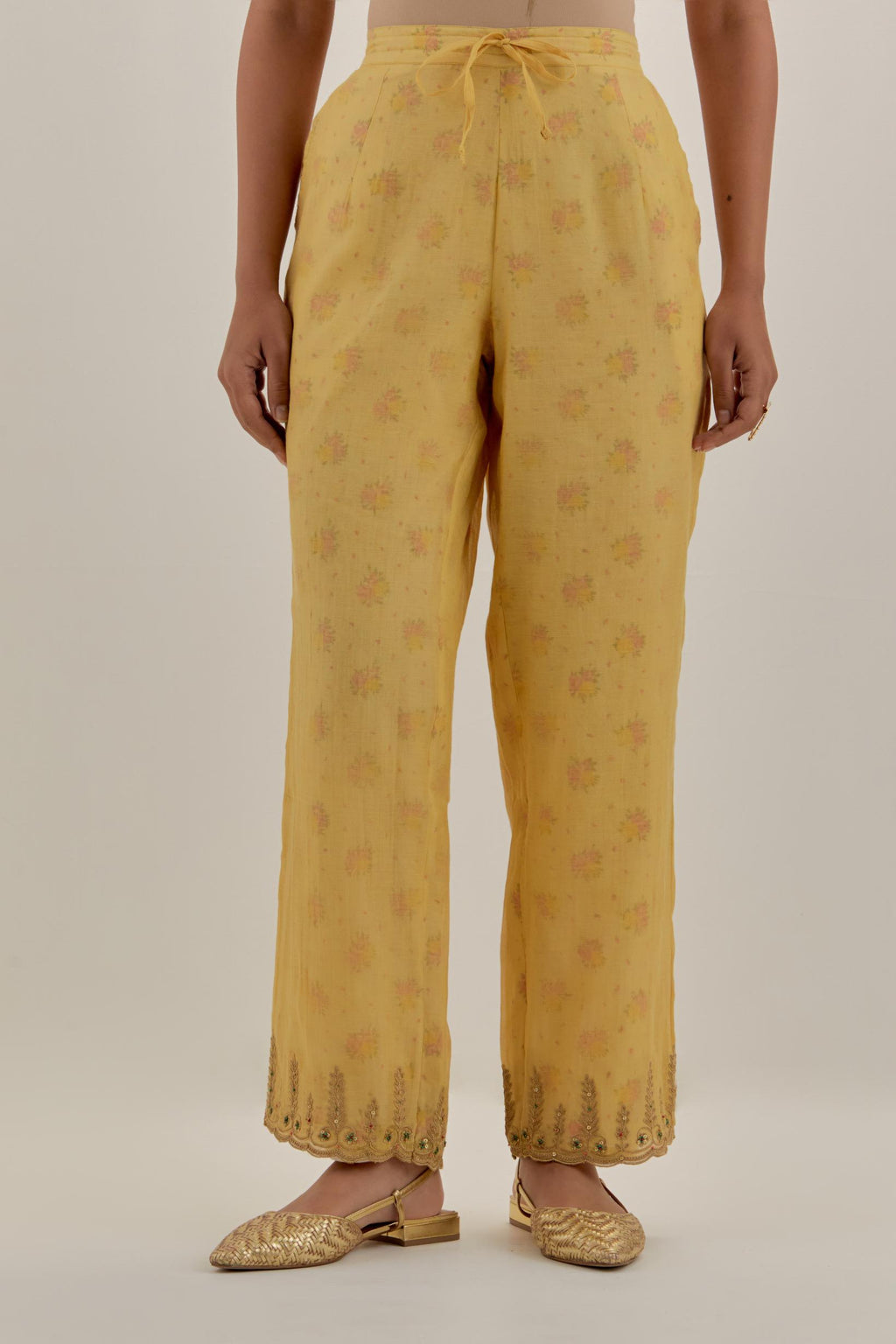 Yellow tissue chanderi straight pants with light gold dori embroidery at hem.