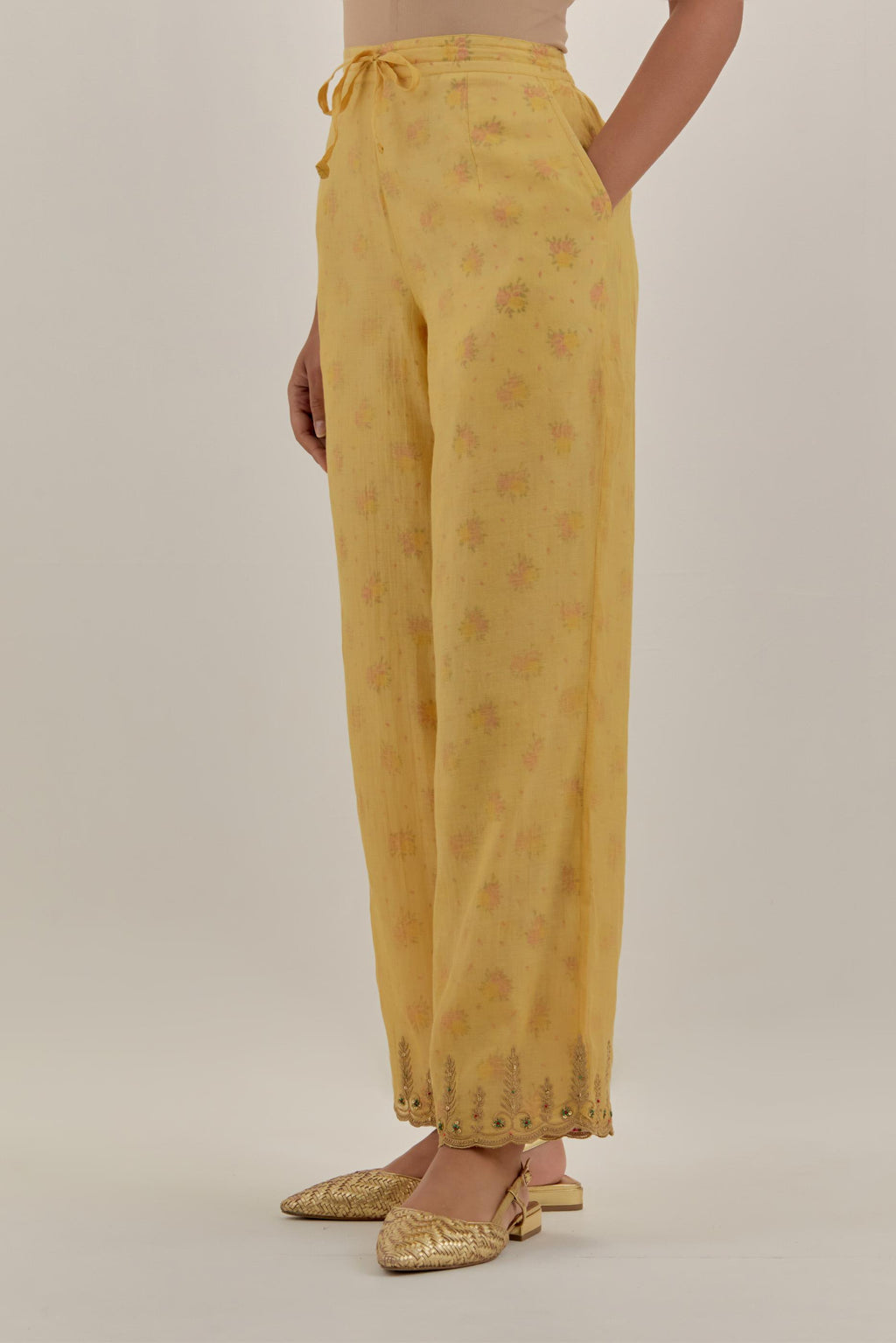 Yellow tissue chanderi straight pants with light gold dori embroidery at hem.