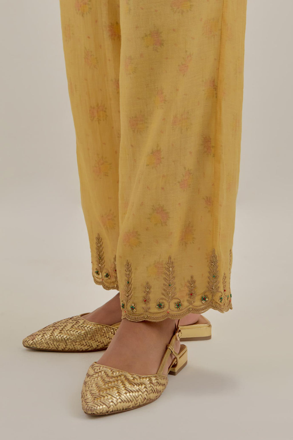 Yellow tissue chanderi straight pants with light gold dori embroidery at hem.