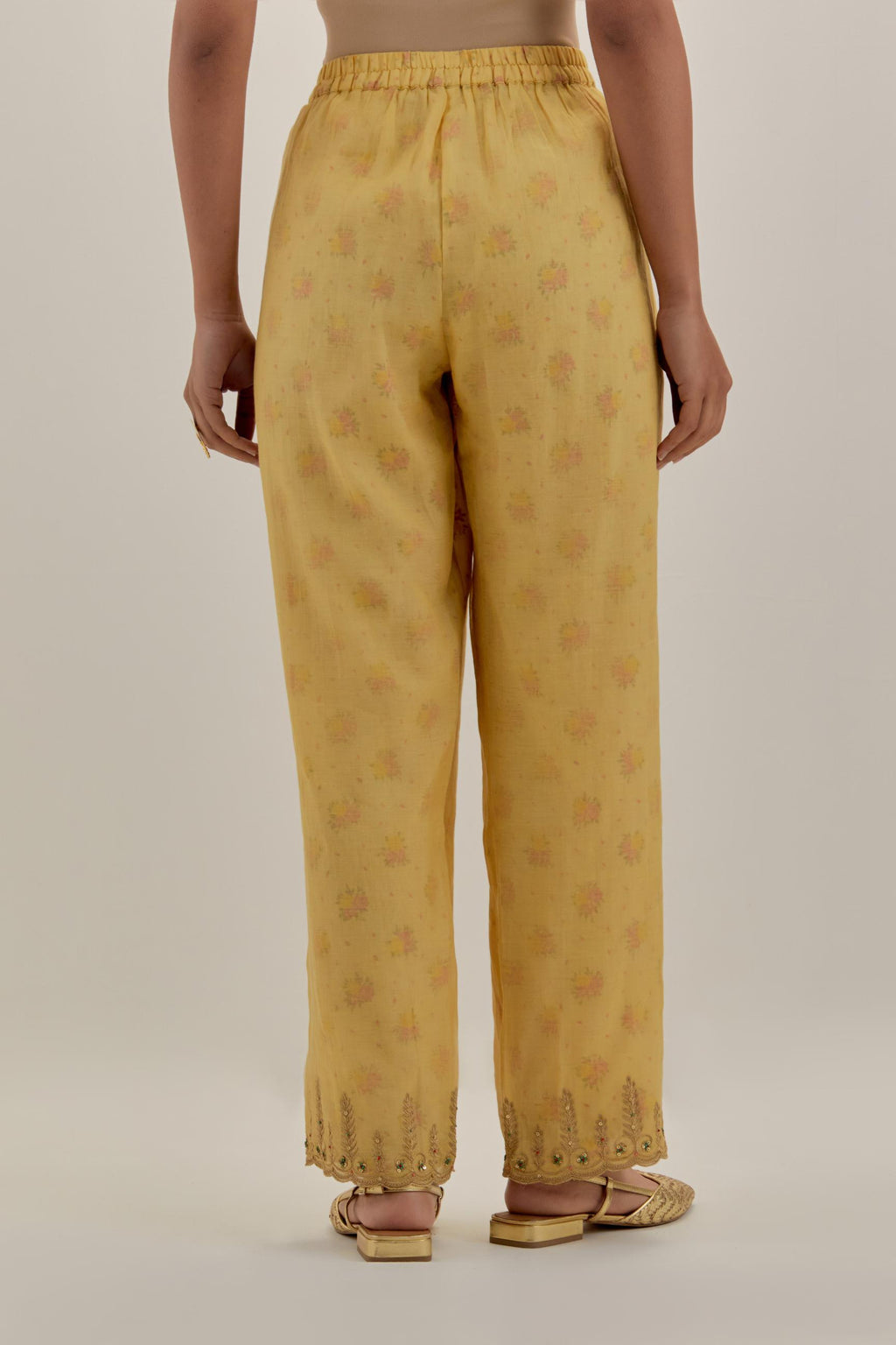 Yellow tissue chanderi straight pants with light gold dori embroidery at hem.