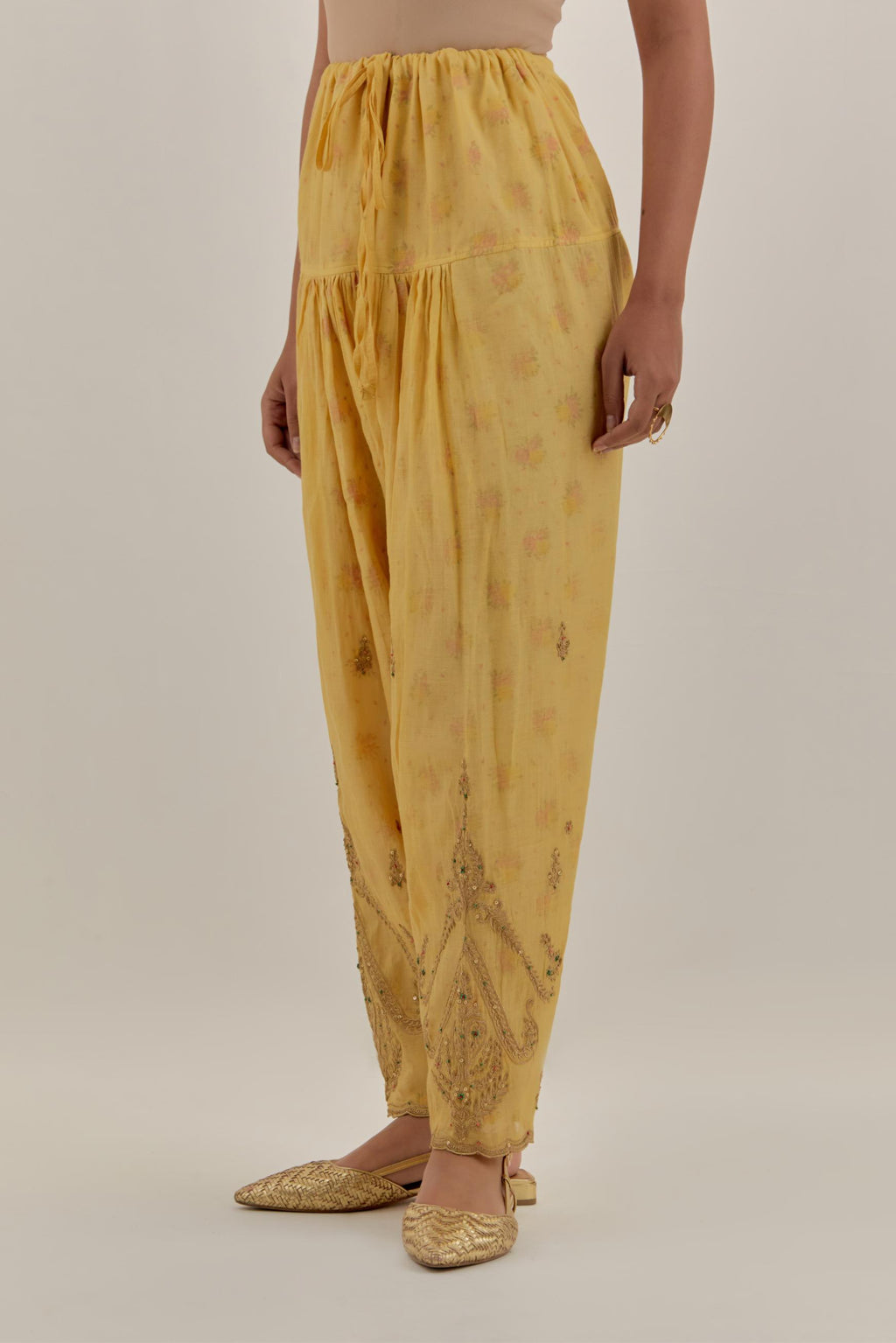 Yellow tissue chanderi salwar with gold dori embroidery, highlighted with multi beads & gold sequins.