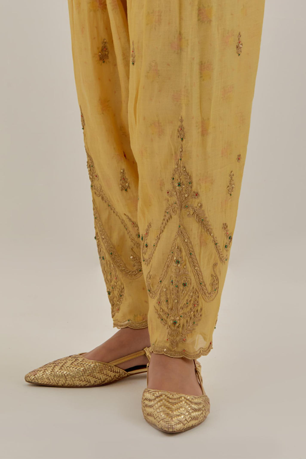 Yellow tissue chanderi salwar with gold dori embroidery, highlighted with multi beads & gold sequins.