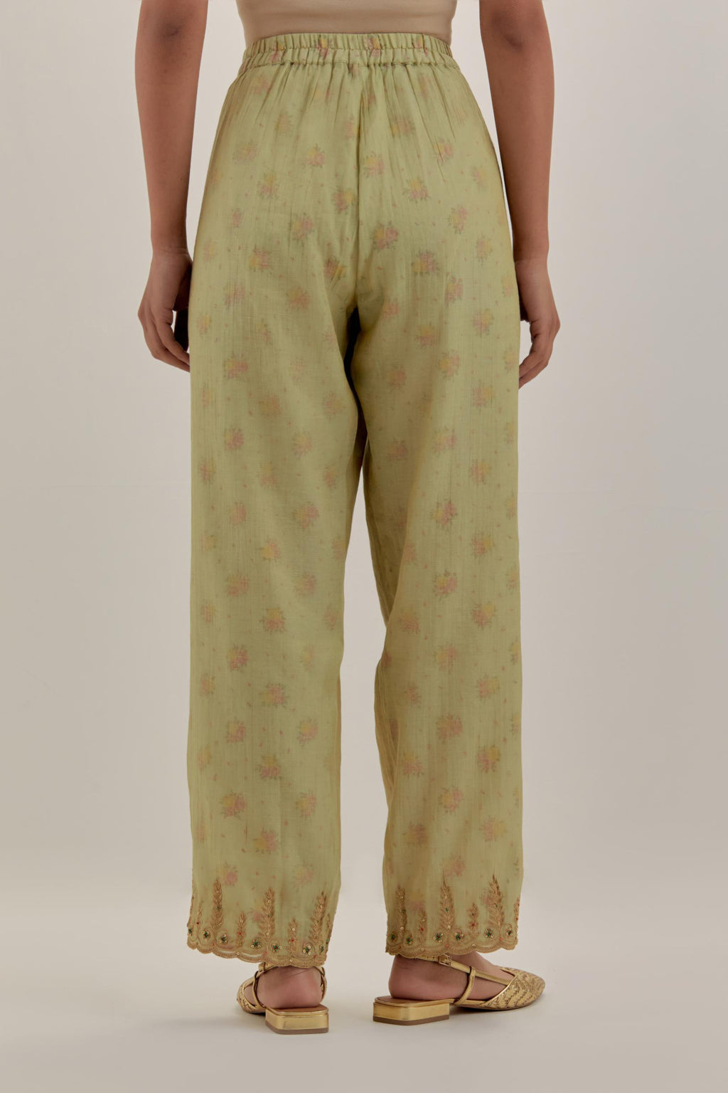 Green tissue chanderi straight pants with light gold dori embroidery at hem.