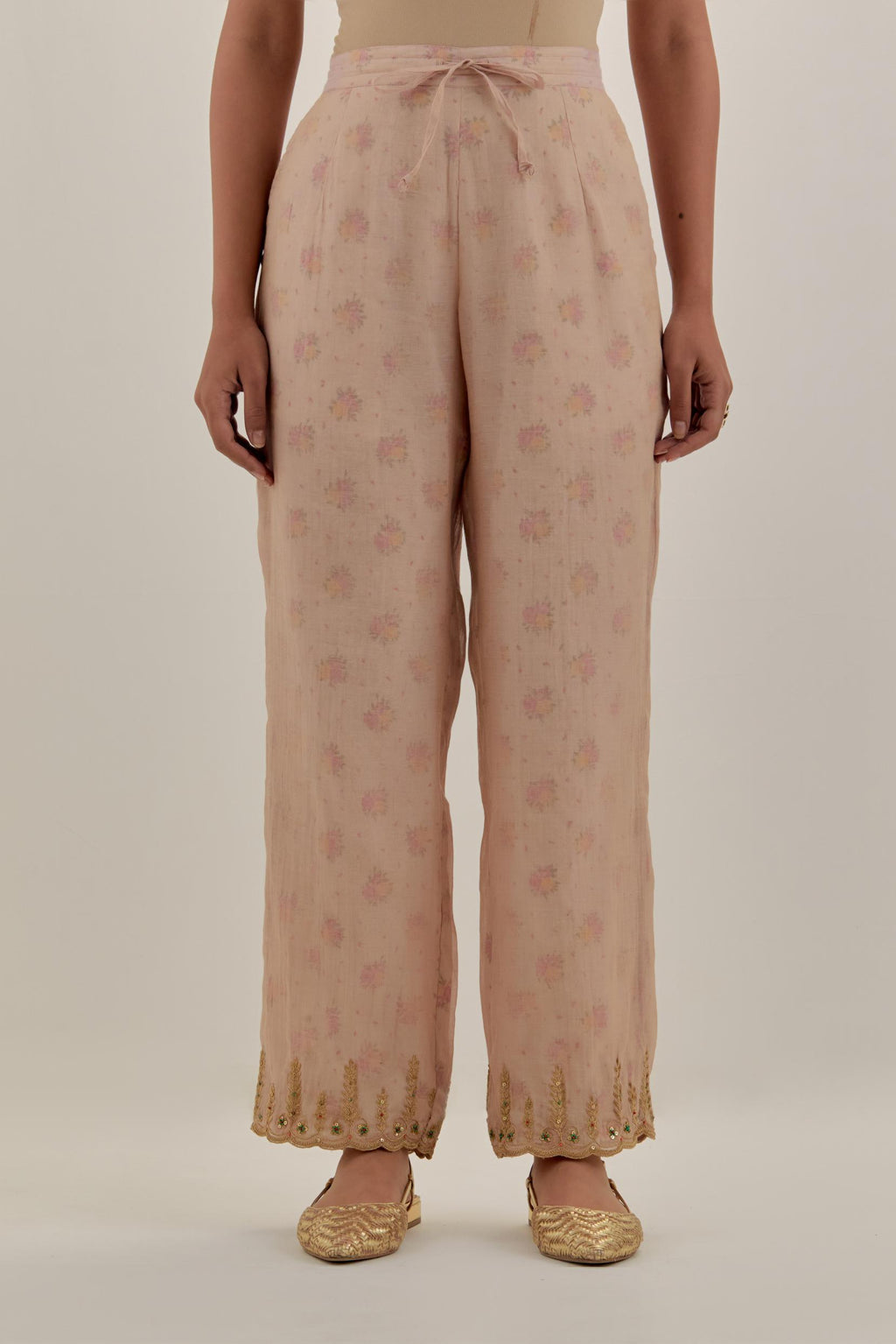 Pink tissue chanderi straight pants with light gold dori embroidery at hem.