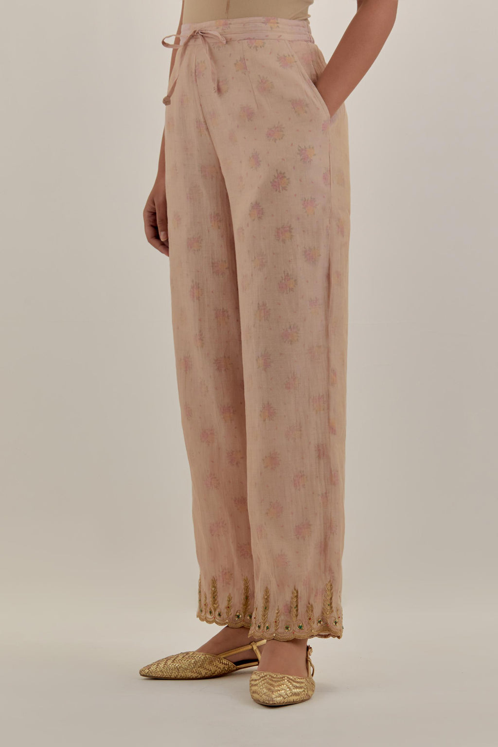 Pink tissue chanderi straight pants with light gold dori embroidery at hem.