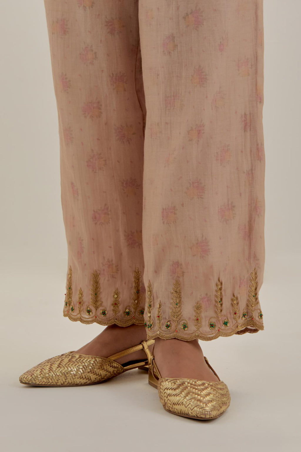 Pink tissue chanderi straight pants with light gold dori embroidery at hem.