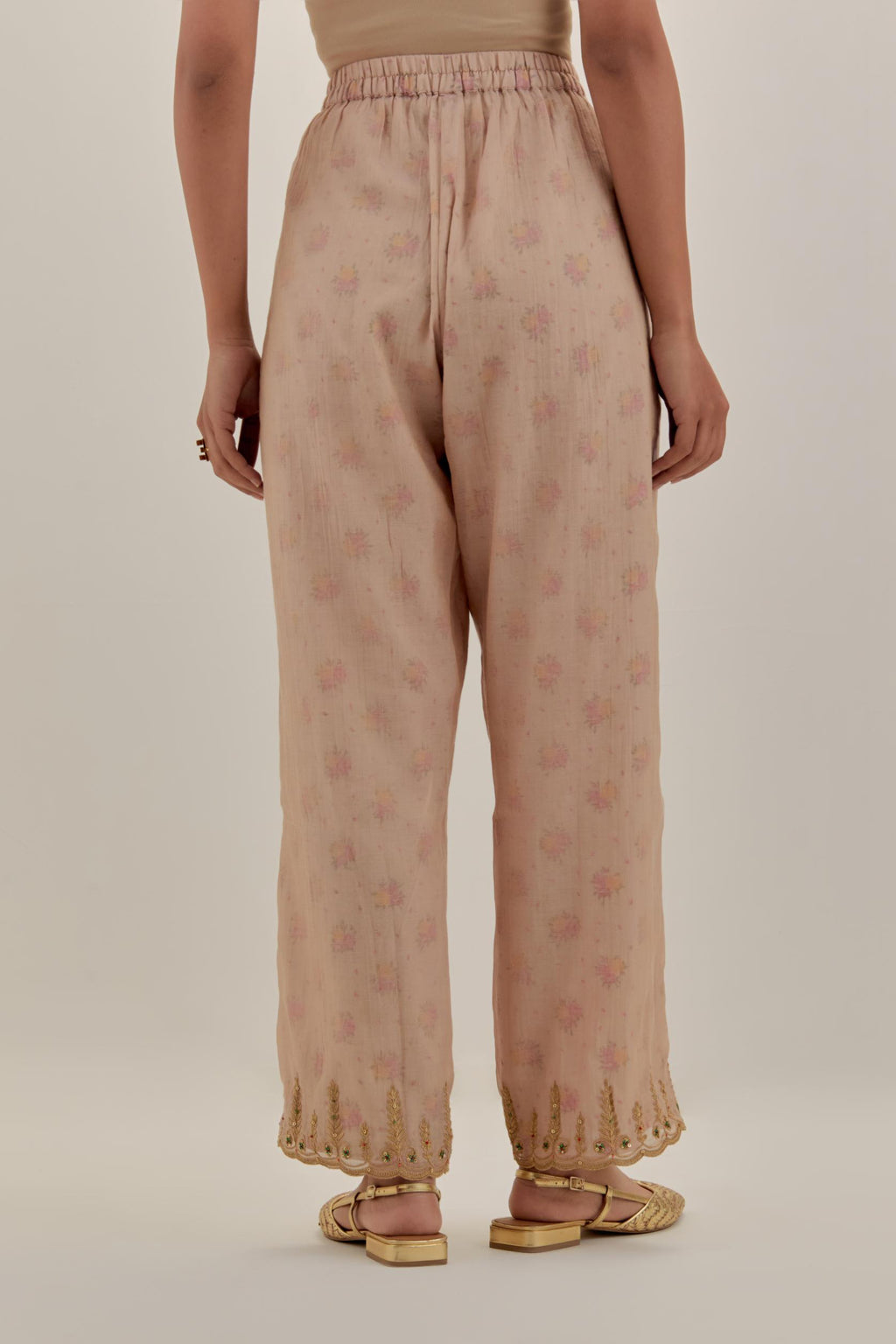 Pink tissue chanderi straight pants with light gold dori embroidery at hem.