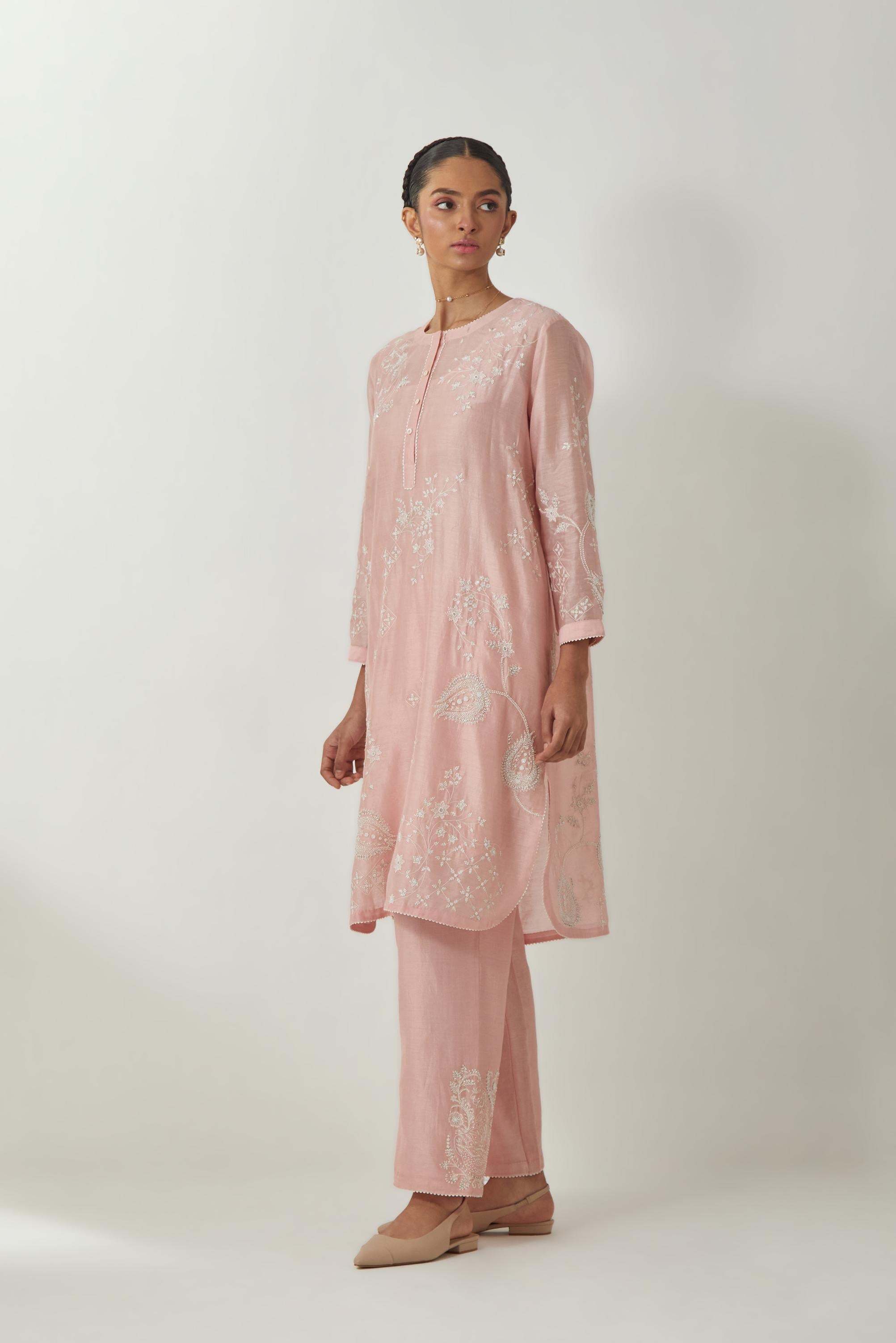Pink silk Chandri straight short kurta with all-over off white silk thread embroidery, highlighted with beads and sequins work,  paired with Pink silk Chanderi straight pants with embroidered boota at sides, highlighted with sequins and beads.