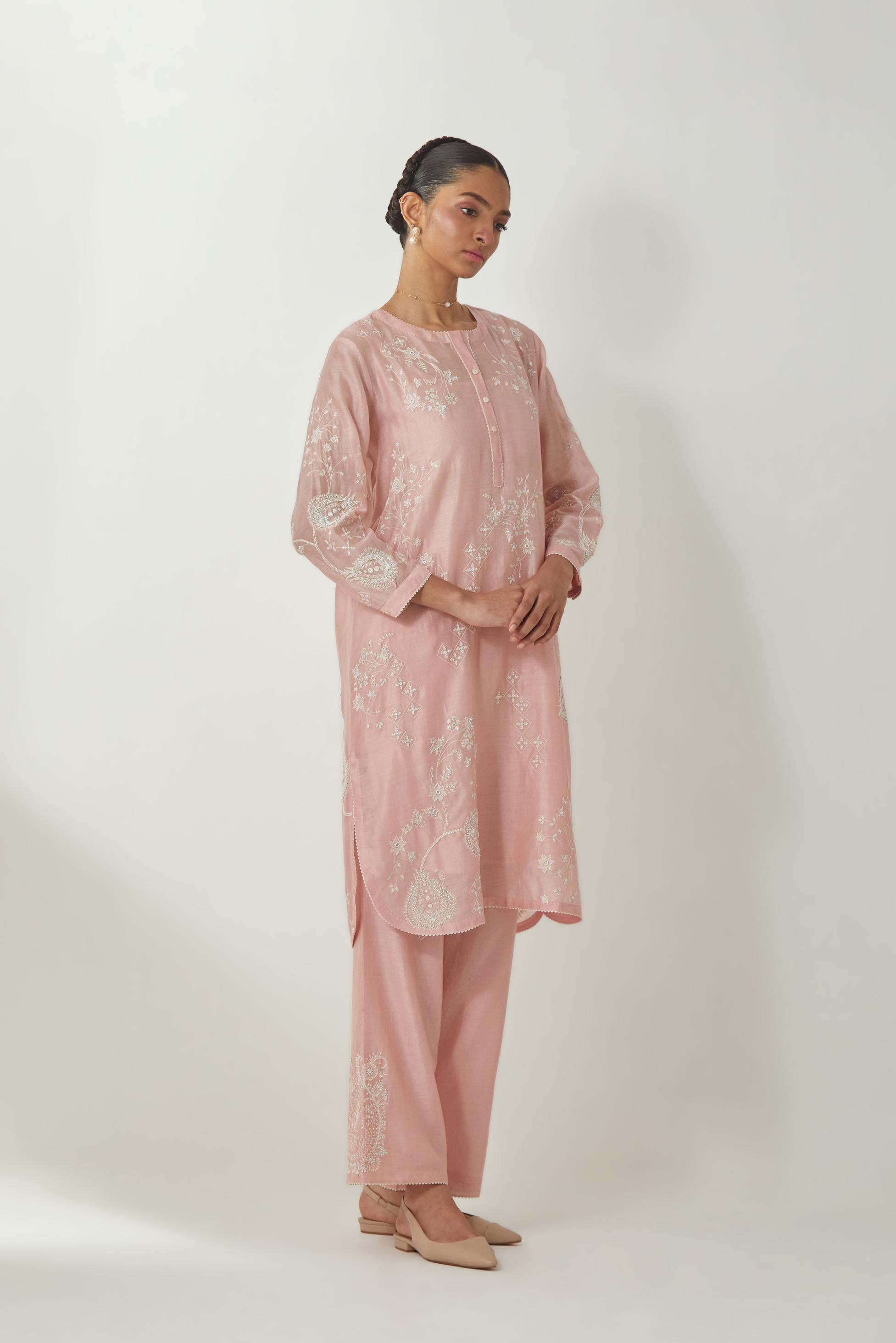Pink silk Chandri straight short kurta with all-over off white silk thread embroidery, highlighted with beads and sequins work,  paired with Pink silk Chanderi straight pants with embroidered boota at sides, highlighted with sequins and beads.