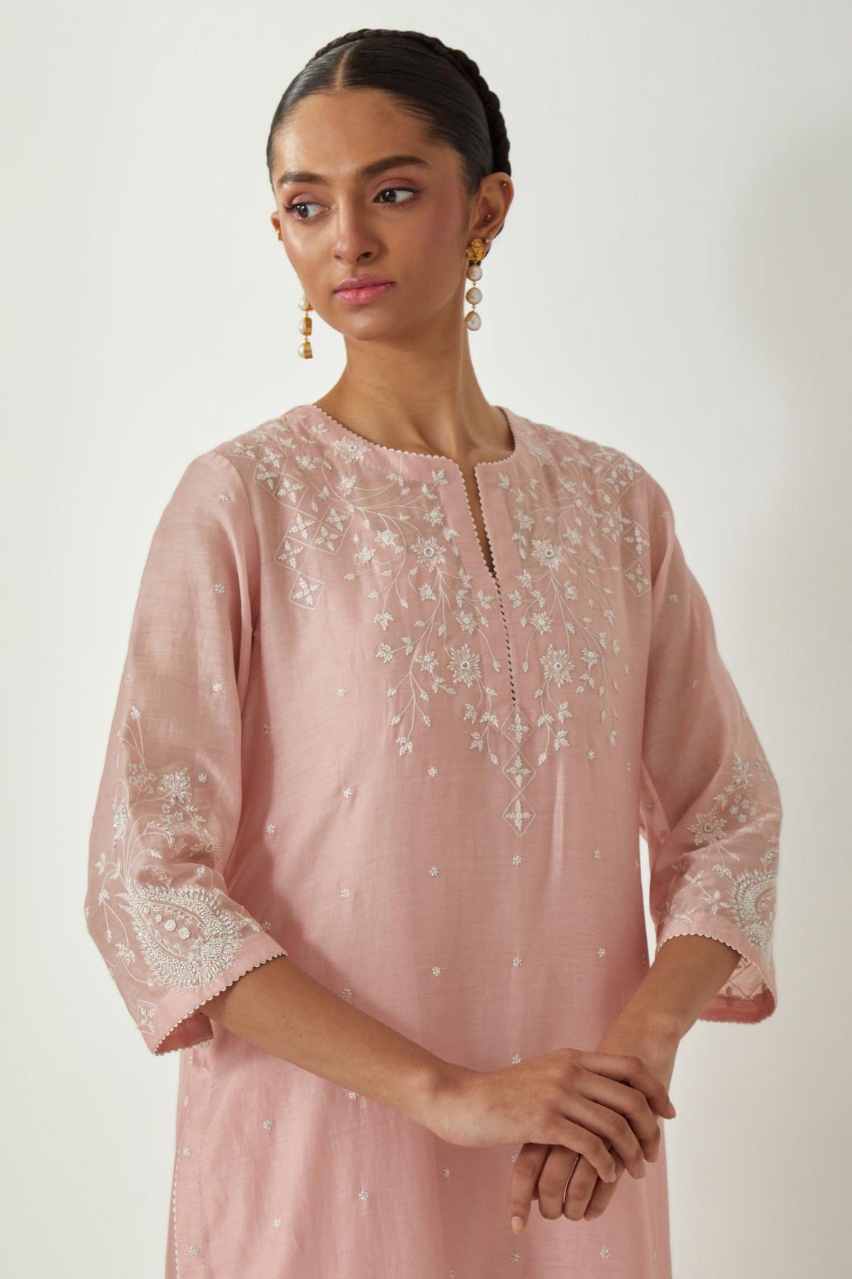 Pink silk Chanderi straight mid length kurta set with all-over off white silk thread embroidery, highlighted with beads, and sequins work at neck & hem.