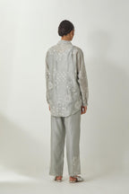 Bluish Grey silk Chanderi shirt with all-over off white silk thread embroidery, highlighted with sequins and beads work, paired with Bluish Grey silk Chanderi straight pants with embroidered boota at sides, highlighted with sequins and beads.