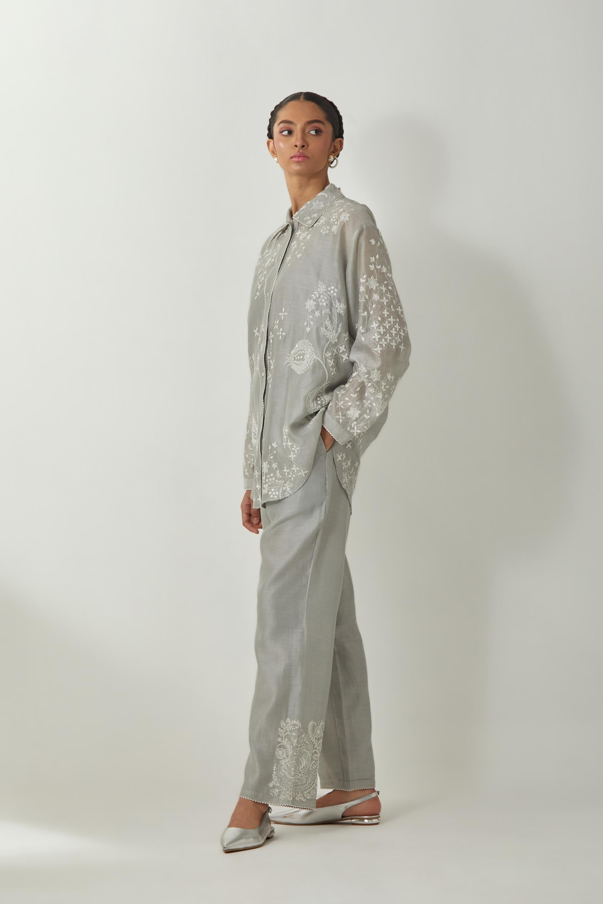 Bluish Grey silk Chanderi shirt with all-over off white silk thread embroidery, highlighted with sequins and beads work, paired with Bluish Grey silk Chanderi straight pants with embroidered boota at sides, highlighted with sequins and beads.