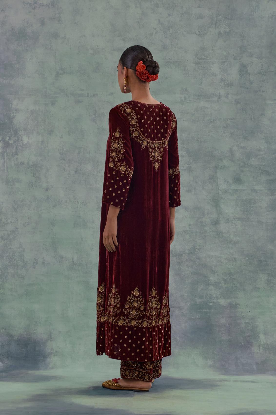 Deep maroon straight long kurta set in Silk Velvet with hand-embroidered bead, sequins and zari detailing on neck, sleeves and hem.