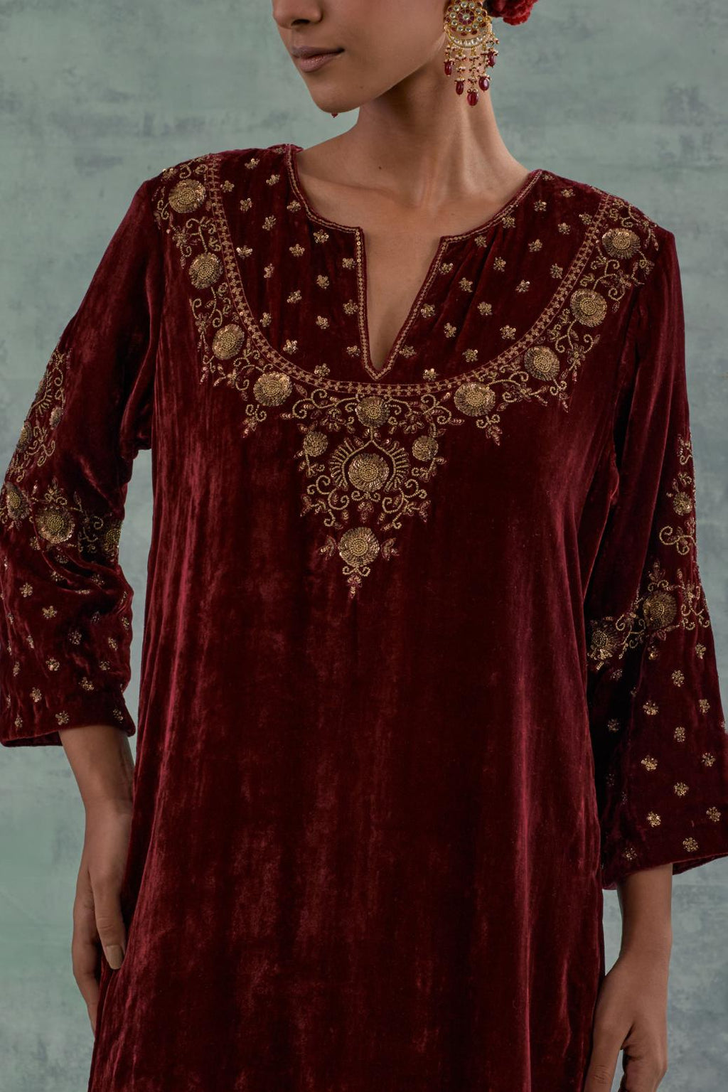 Deep maroon straight long kurta set in Silk Velvet with hand-embroidered bead, sequins and zari detailing on neck, sleeves and hem.