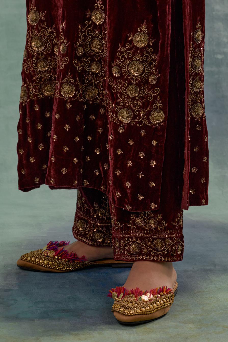 Deep maroon straight long kurta set in Silk Velvet with hand-embroidered bead, sequins and zari detailing on neck, sleeves and hem.