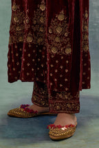 Deep maroon straight long kurta set in Silk Velvet with hand-embroidered bead, sequins and zari detailing on neck, sleeves and hem.