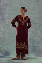 Deep maroon straight long kurta set in Silk Velvet with hand-embroidered bead, sequins and zari detailing on neck, sleeves and hem.