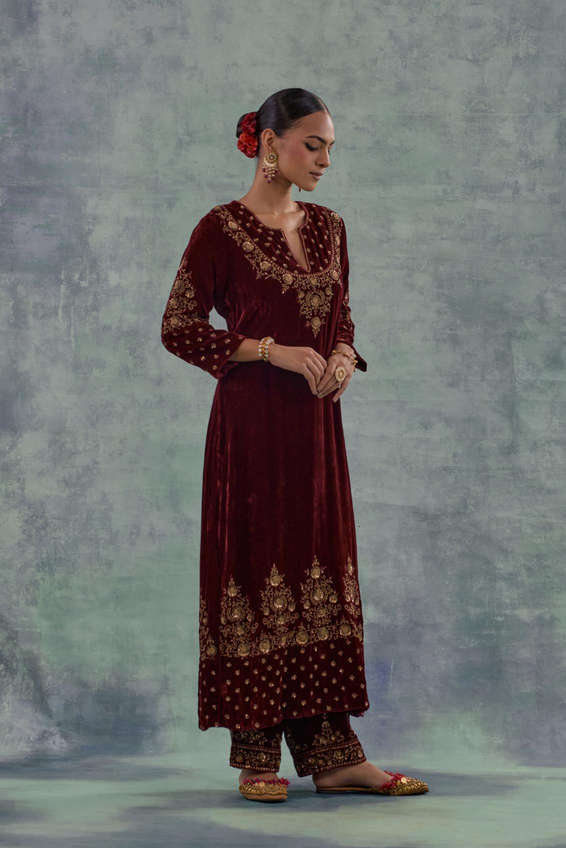 Deep maroon straight long kurta set in Silk Velvet with hand-embroidered bead, sequins and zari detailing on neck, sleeves and hem.