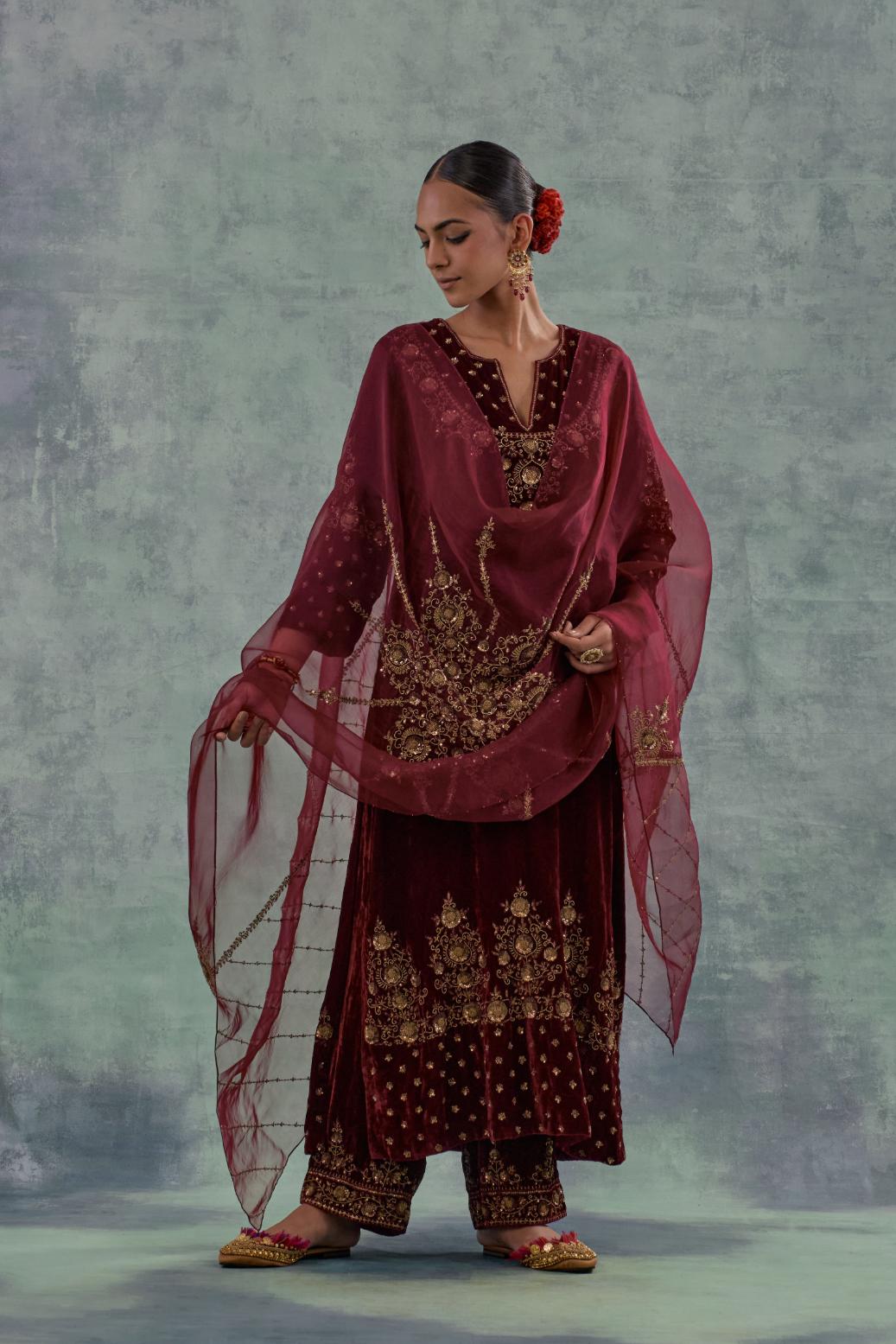 Deep maroon straight long kurta set in Silk Velvet with hand-embroidered bead, sequins and zari detailing on neck, sleeves and hem.