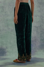 Emerald Green velvet straight pants. The hem is highlighted with hand-embroidered bead, sequins and zari motifs.